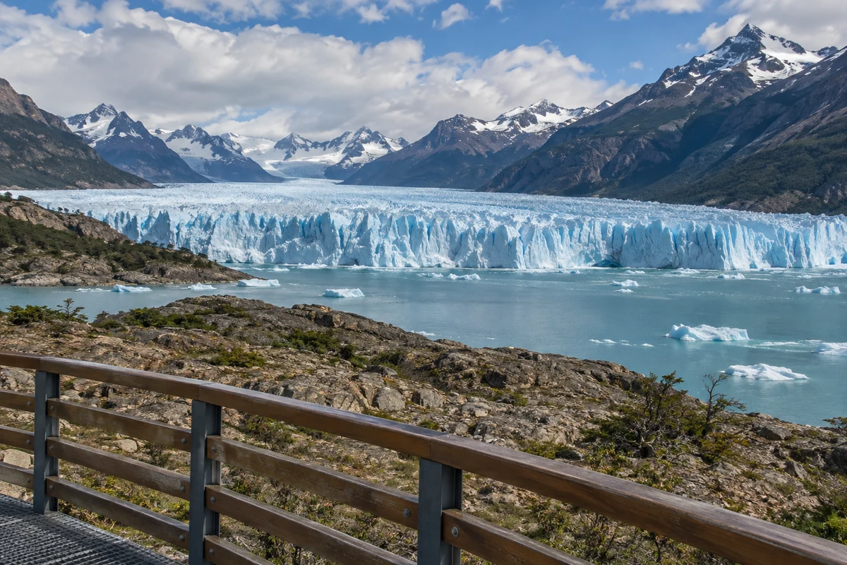 Conceptual view of a glacier across a lake from a railed viewpoint