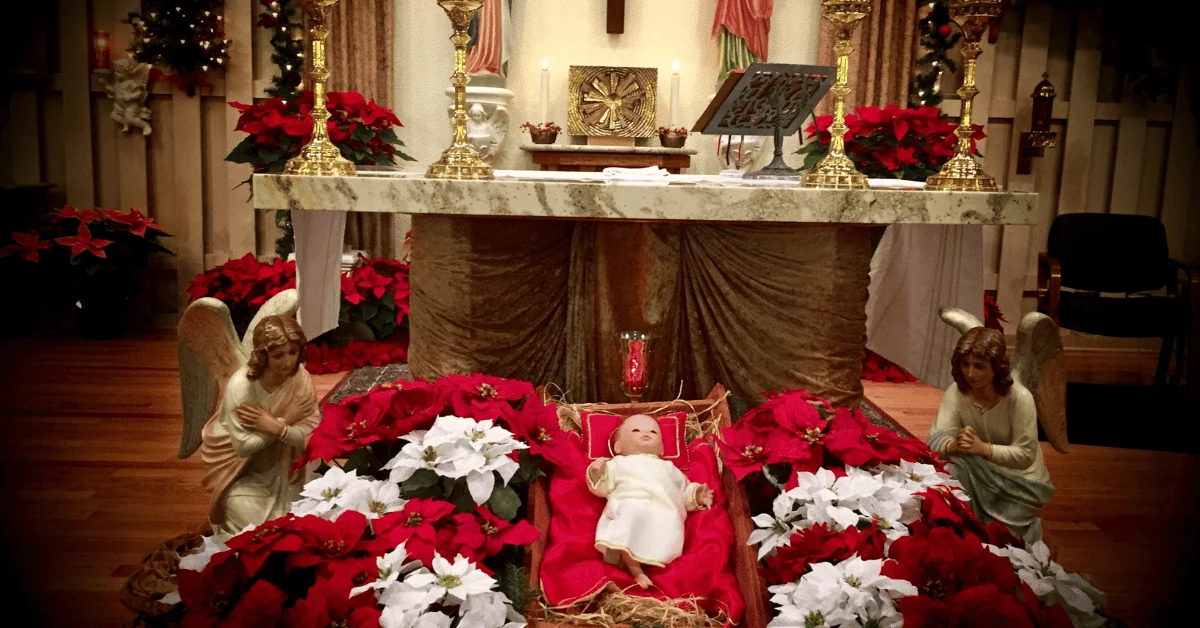 Une crèche et des poinsettias décorent le pied d’un autel